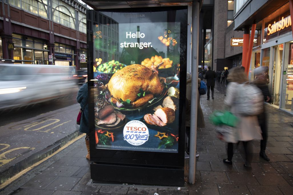 A bus shelter in London with an advertisement for a Tesco Christmas turkey on it