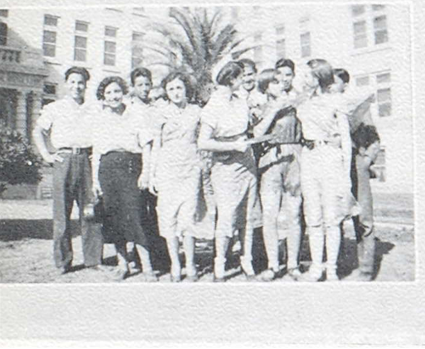 Group of teenagers in front of a school building.