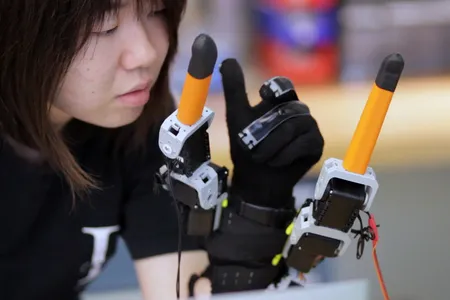 Faye Wu, a graduate student in mechanical engineering, demonstrates the "supernumerary robotic fingers."