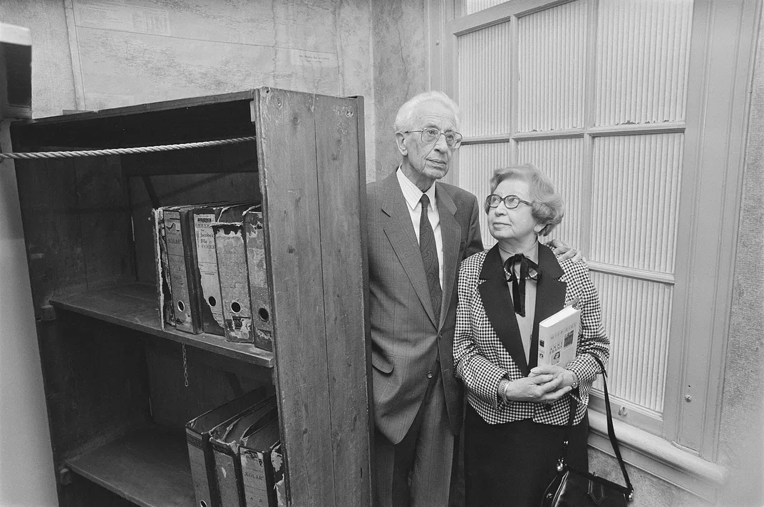 Jan and Miep Gies in front of the bookcase that hid the entrance to the Secret Annex