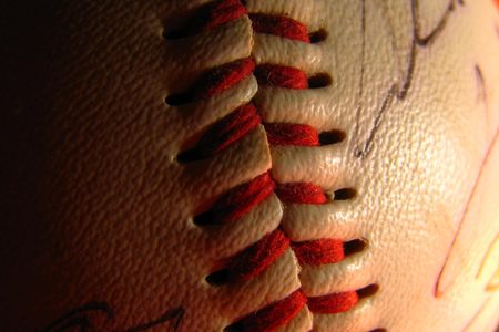 Players&rsquo; signatures are blurred as the red threading of this baseball comes into focus.

