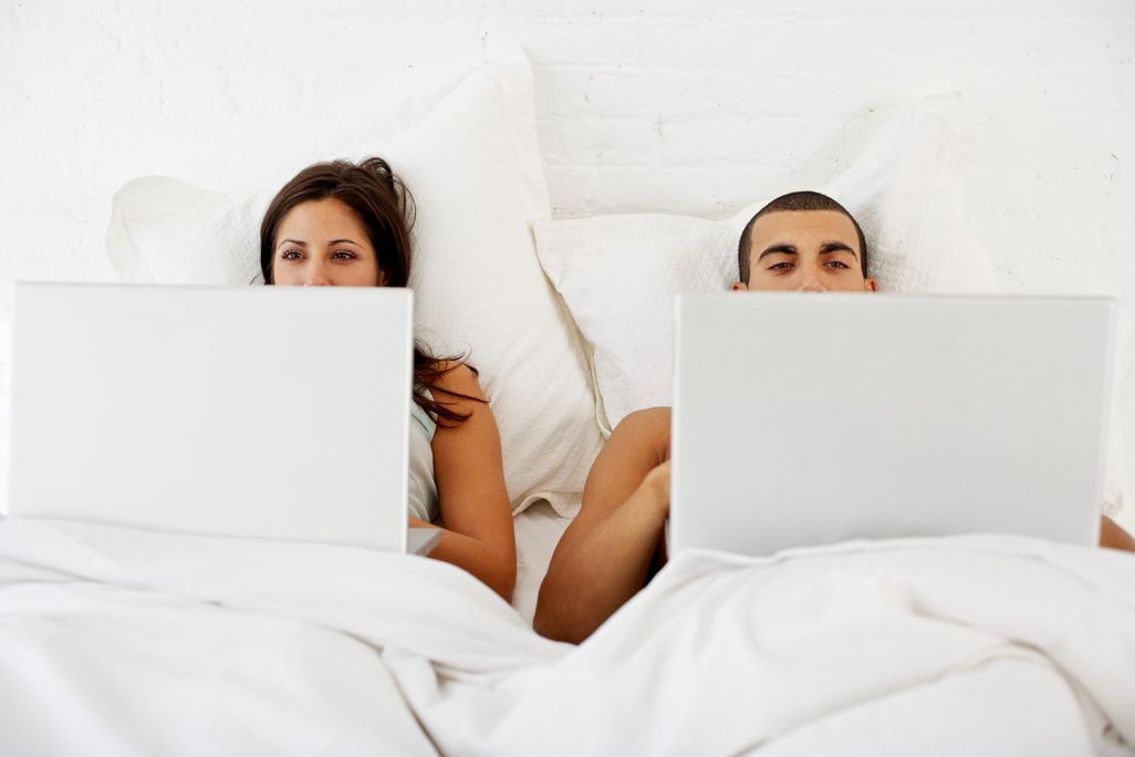 Couple on Laptops in bed