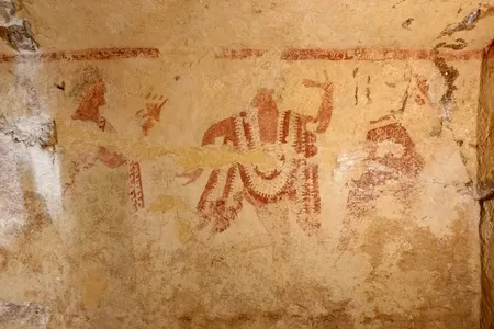 The left wall features a painting of men and women dancing around a flute player.