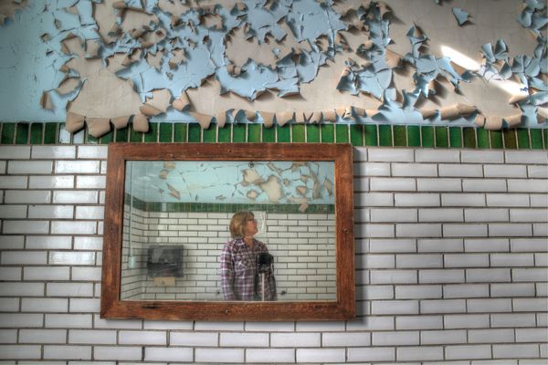 Self portrait in mirror of an abandoned school bathroom thumbnail