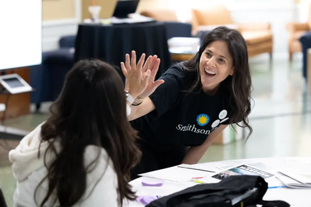 Woman with Smithsonian shirt gives girl a high five