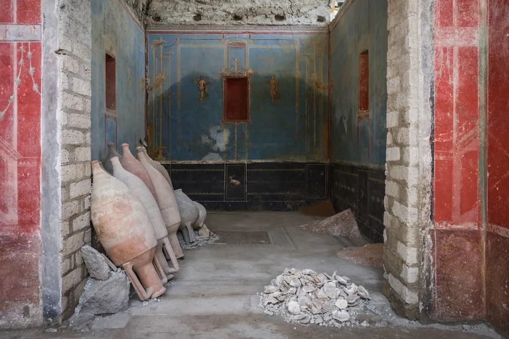 Room with blue walls with jugs leaning up against one wall