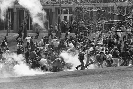 Anti-war demonstrators at Kent State University run as National Guardsmen fire tear gas and bullets into the crowd.