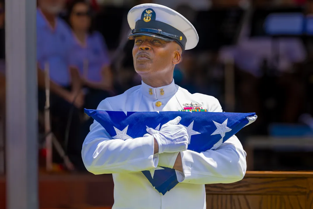 7. -Retired U.S. Navy Command Master Chief Mack Ellis embraces an American flag following his reading of “I Am the Flag,” a 1994 poem written by U.S. Marine Howard Schnauber, at a Memorial Day event near Jacksonville, Florida.