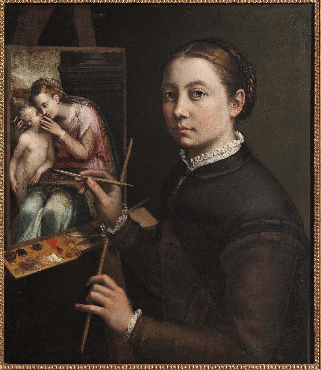 A portrait of a pale woman in dark simple dress, holding the viewer's gaze while she paints a religious scene