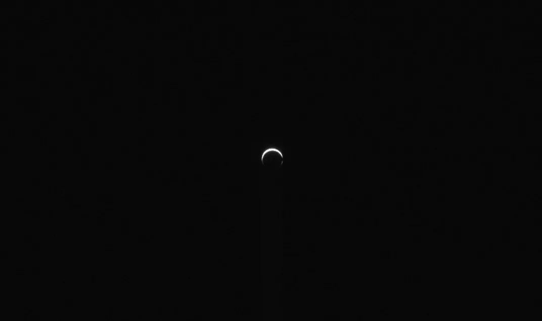 a small Mars seen at a distance with the upper part lit as a crescent