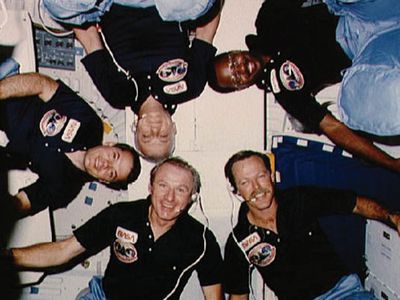 Dubbed the "human satellite," McCandless (bottom center, with the 1984 Challenger crew, including pilot-photographer Gibson, upper left) now works on space robots.
