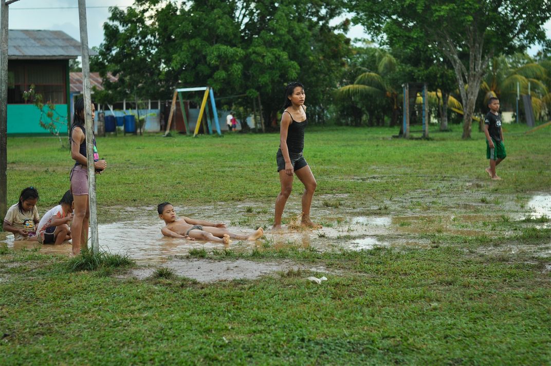 Shipibo tribe children (Peruvian Amazon) playing football after rain