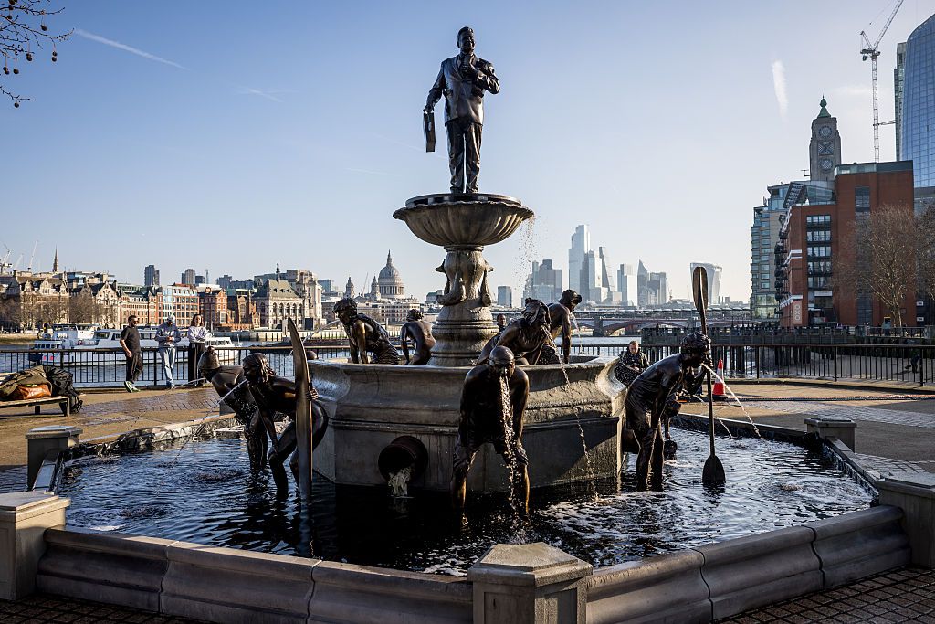 a fountain in downtown London near the Thames river shows people vomiting water