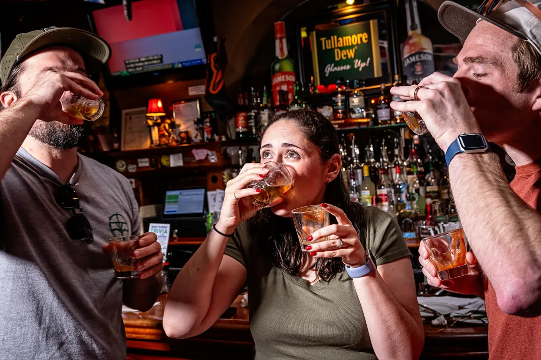 Three latter-day visitors gamely slurp down oyster shooters at Middleton Tavern