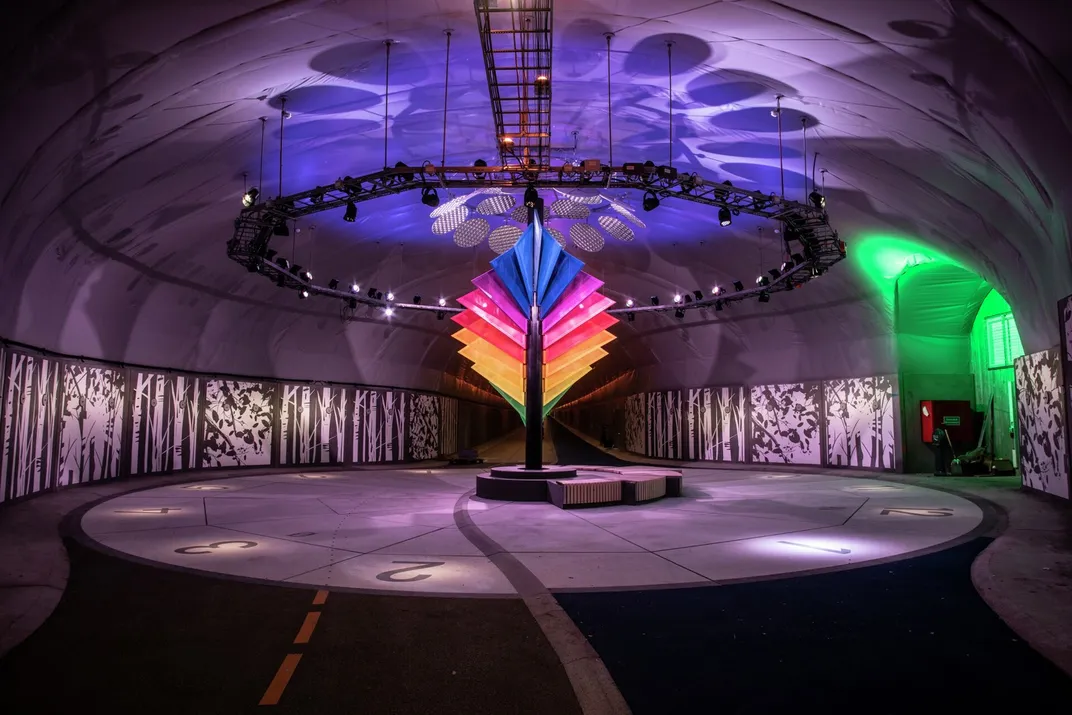 Rainbow art installation inside a dark tunnel