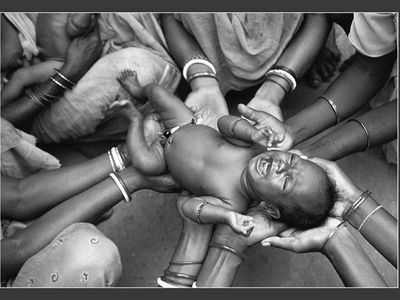 GRAND PRIZE WINNER
A tribal birth in India
Purulia, India &bull; Photographed August 2007
Six days after Betka Tudu's birth, female relatives and neighbors in the West Bengal village of Purulia gathered to bless him and "to protect him from harm's way," says Dey. Born into the Santhal tribe, Betka "unknowingly drew his distant kin closer than ever." &mdash; Abigail Tucker

