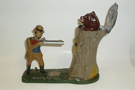 In this intricate mechanical bank, the user balances a coin on the miniature man's gun, which then shoots the coin into a slot in the tree.