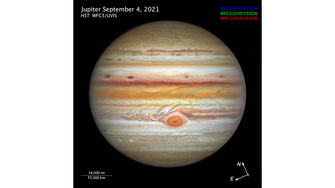 An image of planet Jupiter taken by the Hubble Space Telescope. The planet's atmopshere is riddled with rusty, orange colored bands and white swirls
