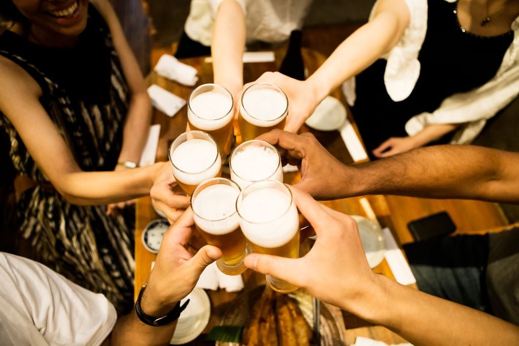 A group of friend cheer full beer glasses together