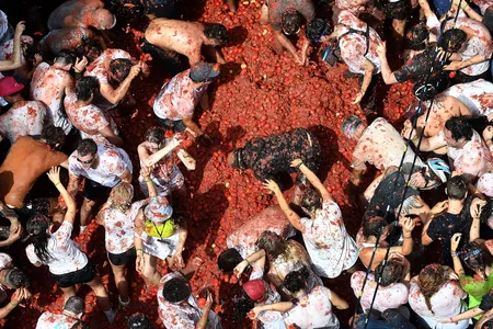 Revelers throw tomatoes during the annual Tomatina festival in Bu&ntilde;ol on August 27, 2025.