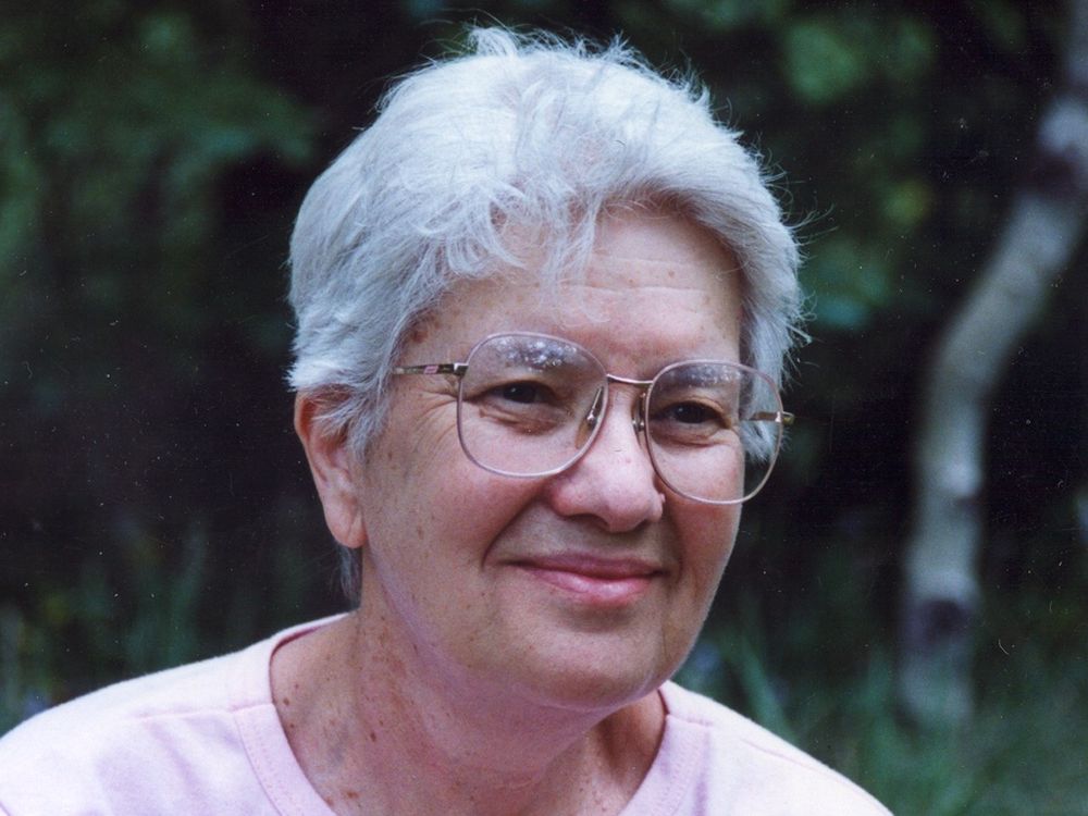 Vera Rubin in front of a green wooded area.