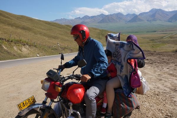 Family on motorbike at rest stop, Xinjiang thumbnail
