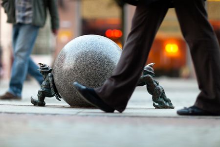 Pedestrians walking by the the Dwarfs of Wroclaw on Świdnicka Street, the main shopping street in the city.