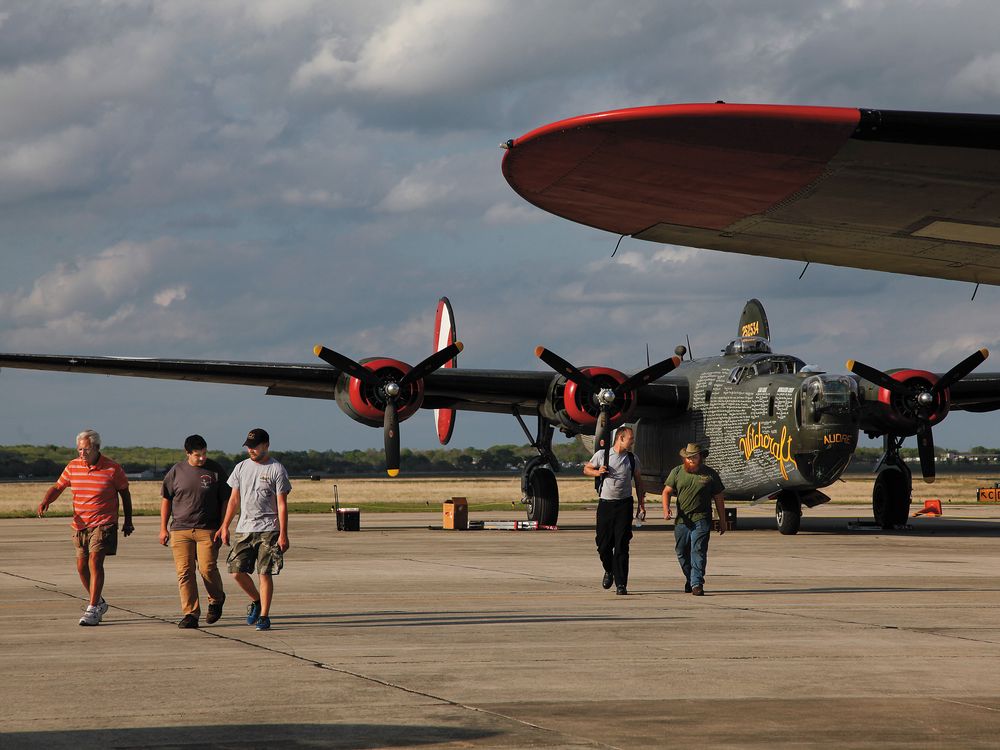 the roadies walk away from the last B-24J left flying