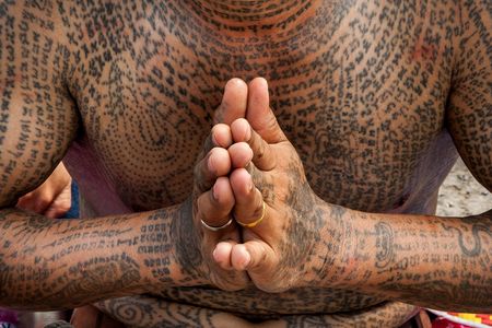 A tattooed devotee prays at the annual tattoo festival at Wat Bang Phra in Nakhon Pathom, Thailand.
