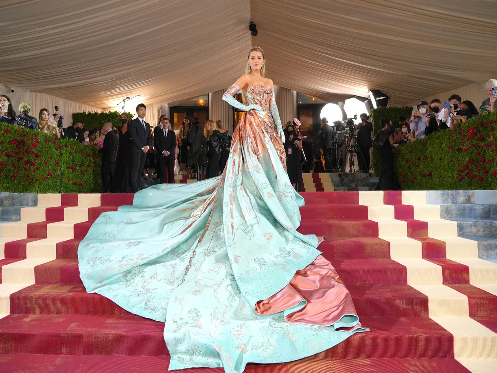 Actress Blake Lively wore a gown whose copper bow unfurled into a blue-green train.