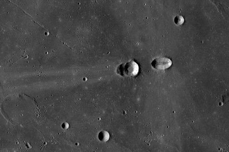 The Lunar Reconnaissance Orbiter captured this view of the craters Messier (right) and Messier A (left). Both craters were likely produced during an oblique impact, only a few degrees above the horizontal. The projectile was traveling from right to left. Messier (at right) was made first, but ricochet and downrange propagation of the top of the projectile (decapitation) made Messier A. Note the ejecta blanket of Messier extend at right angles to the impact direction, while whisker-like rays extend downrange from Messier A in the same direction as the impact.