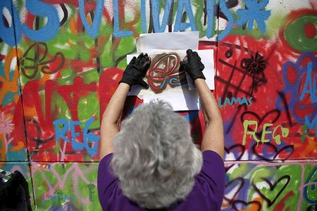 One of the LATA 65 students works on a mural in Lisbon. 