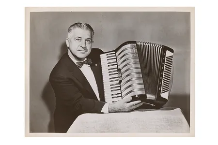 Photograph of John Vassos holding the Marchesa model accordion he designed for M. Hohner, 195-? / unidentified photographer. John Vassos papers, 1915-1989. Archives of American Art, Smithsonian Institution.