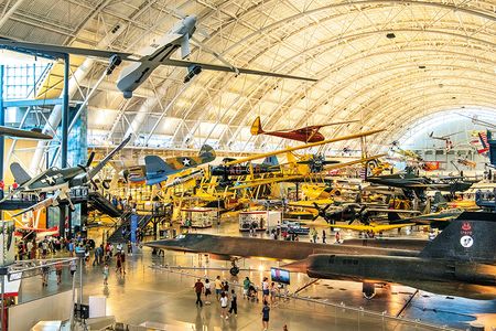 The Boeing Aviation Hangar at the Steven F. Udvar-Hazy Center is a vast open space filled with airplanes on both the floor and hanging from the ceiling, tilted at angles that convey the impression of flight.