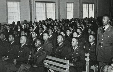 Tuskegee cadets gather at a formal assembly.  The first graduating class is seated in the front row.