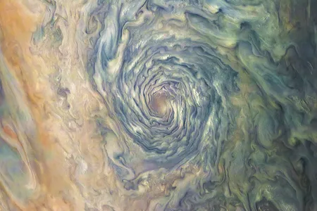 A massive atmospheric vortex on Jupiter is a dizzying swirl of brown, yellow, and green clouds that form a deep tunnel.