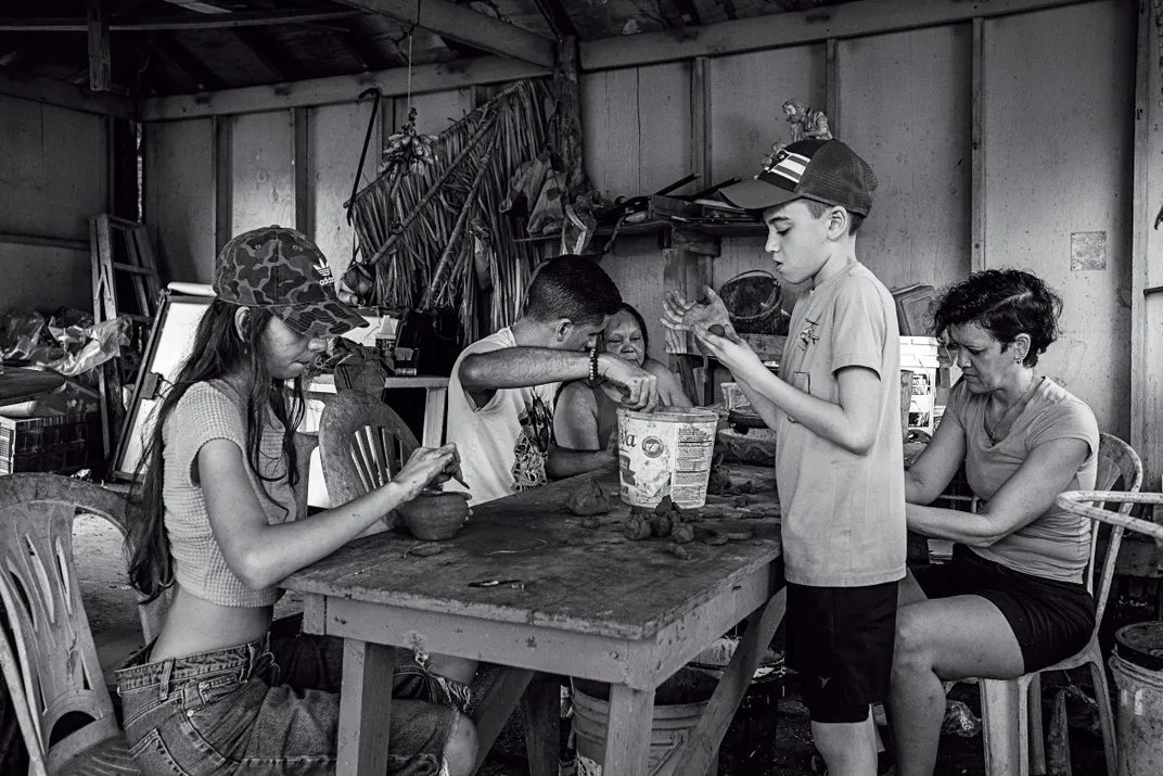 a black and white photograph of people working at a table