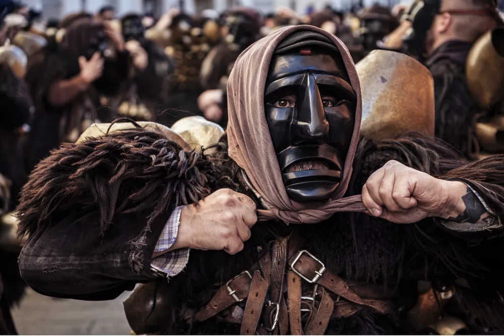 OPENER - Loaded with leather and sheepskins, Salvatore Gungui tightens his headscarf. Although only men dress as Mamuthones, the scarf adds a feminine element.
