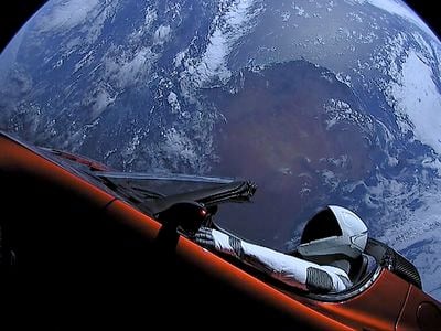 The Tesla Roadster and the mannequin &quot;Starman&quot; on the SpaceX Falcon Heavy upper stage, with Earth in background.