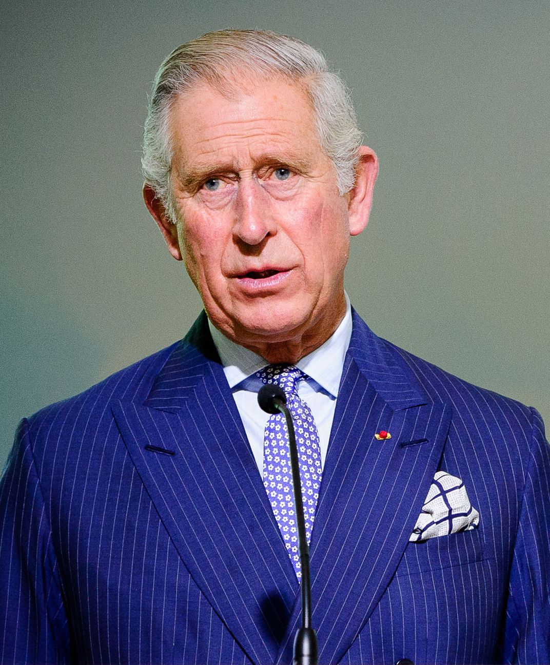 picture of elderly white man in blue pin-striped suit and purple tie with white flowers