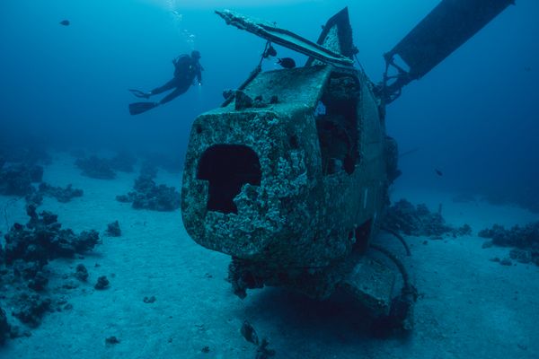 Diver next to a submerged helicopter thumbnail