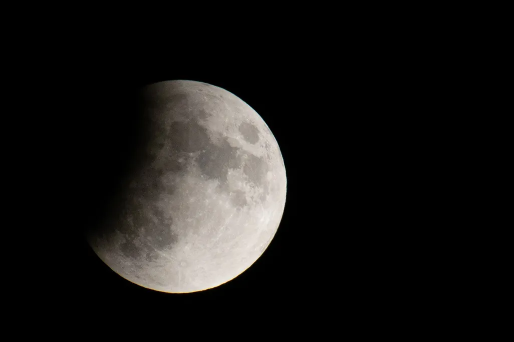An image of the moon hidden partially by Earth's shadow.