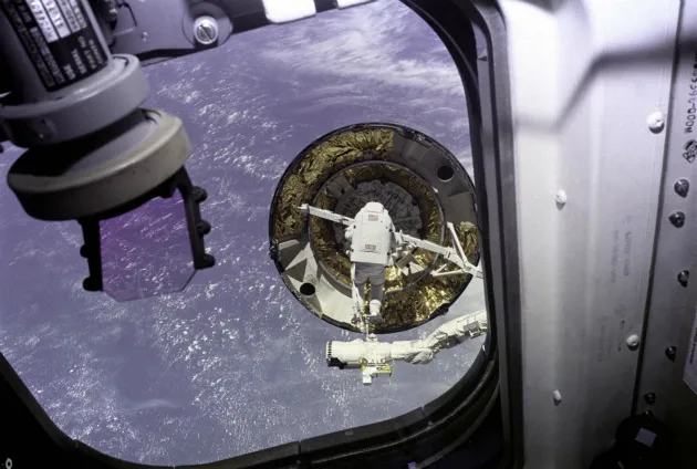 Astronaut Pierre Thuot attempts to capture the wayward satellite