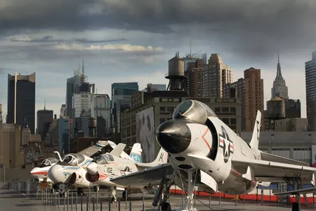 Complementing the New York City skyline, from right: a McDonnell F3H Demon, Vought F-8 Crusader, Grumman A-6 Intruder, and Grumman F-14D Super Tomcat.

