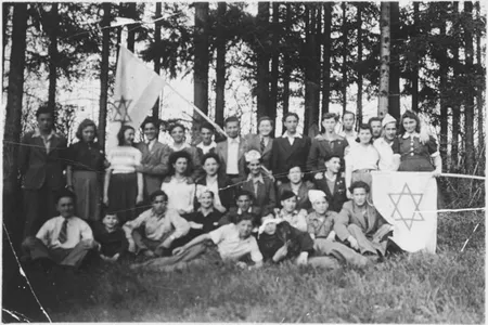 Group with flags in the forest: Michael Walter, Miklos Roth, Szlama Weichselblatt, Avram Leder, Halina Bryks, Naftali Steinberg, Roman Kniker, Jakob Kahan
