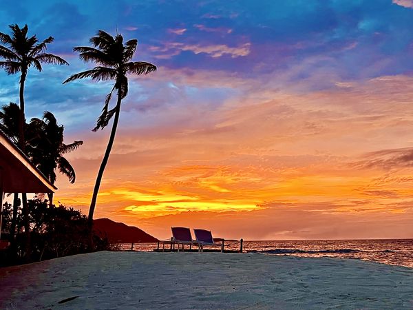 Sunset with a pair of Lounge Chairs on Palm Island thumbnail