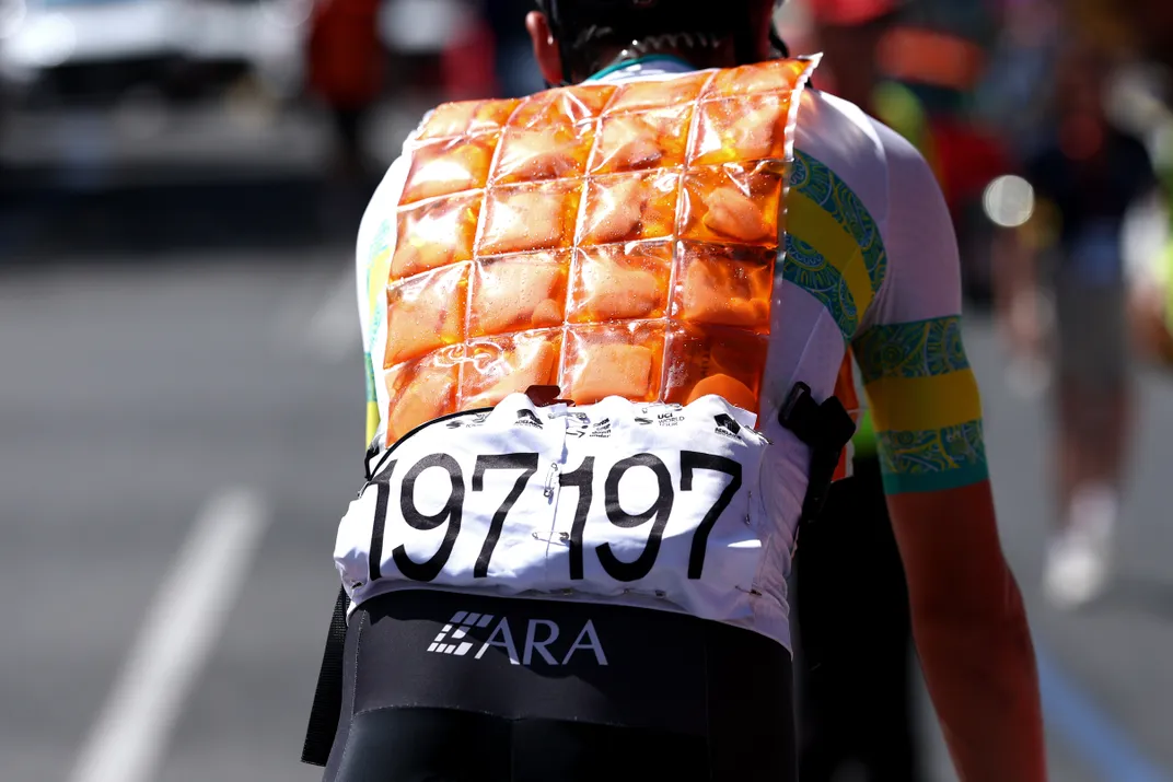 Shot of a cyclist wearing an orange cooling vest, which has small pockets for ice