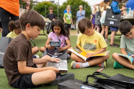 A group of children sit on the grass to read silently to themselves