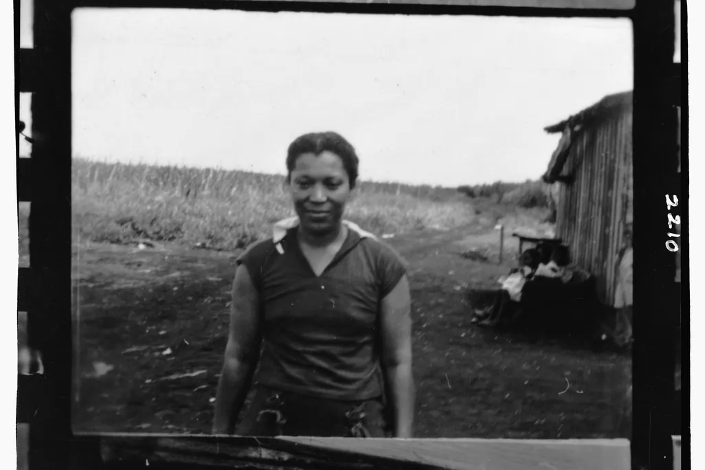 Zora Neale Hurston posing outside of a cabin in Belle Glade, Florida circa 1935 during a folk music recording expedition.