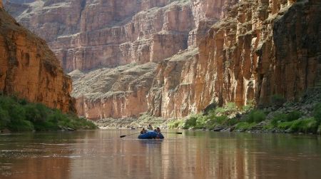 Canyon walls tower above river rafters in the cathedralesque Grand Canyon. Traveling by raft may be the most enjoyable and easiest way to explore the Colorado River, one of the most threatened rivers.